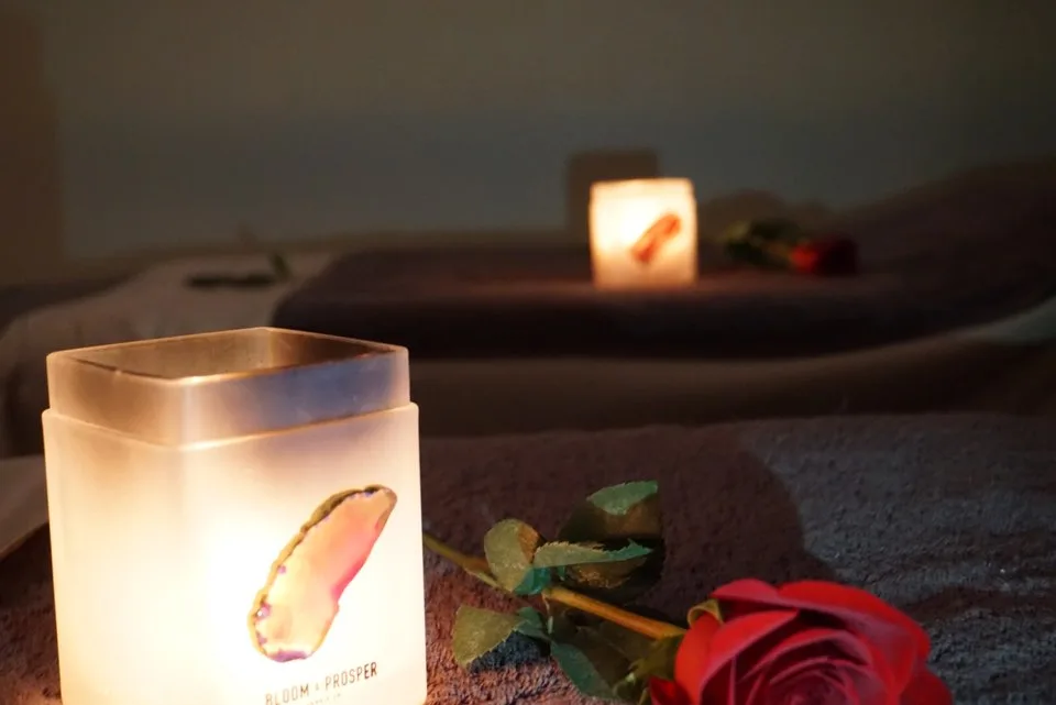 Candle and single rose on a folded towel in the couples room